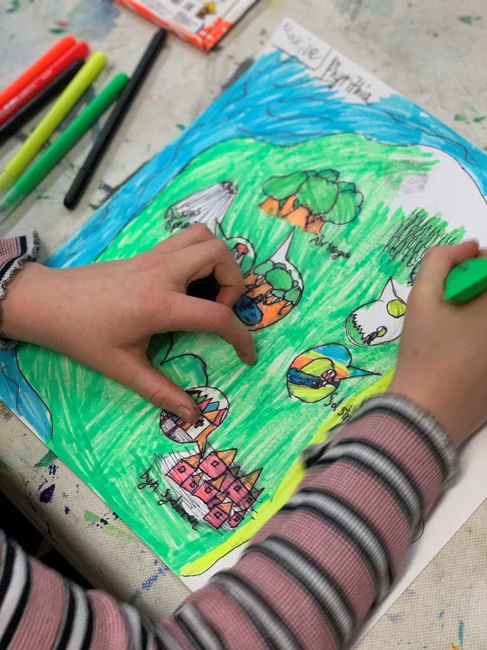 Händerna hos ett barn som ritar en teckning.