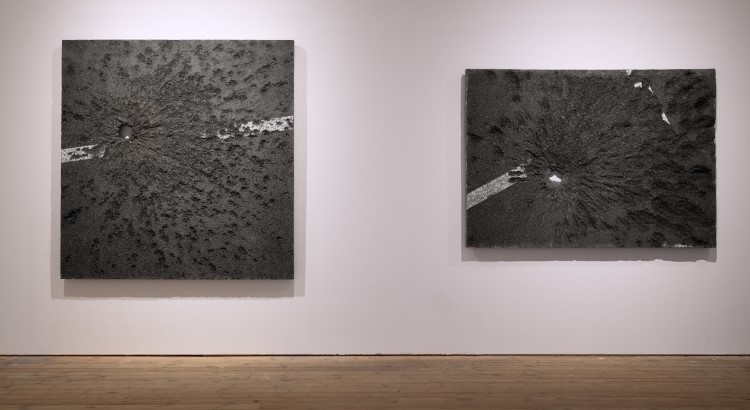 Två fyrkantiga bitar av asfalt som hänger på vägg