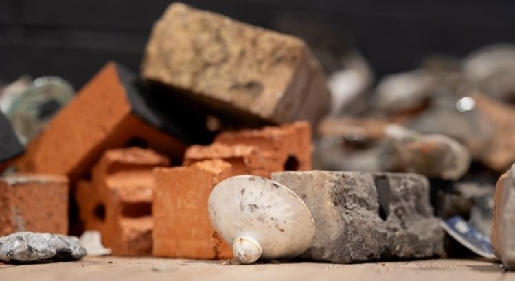 Söndriga tegelstenar och vitt porslinslock på golv